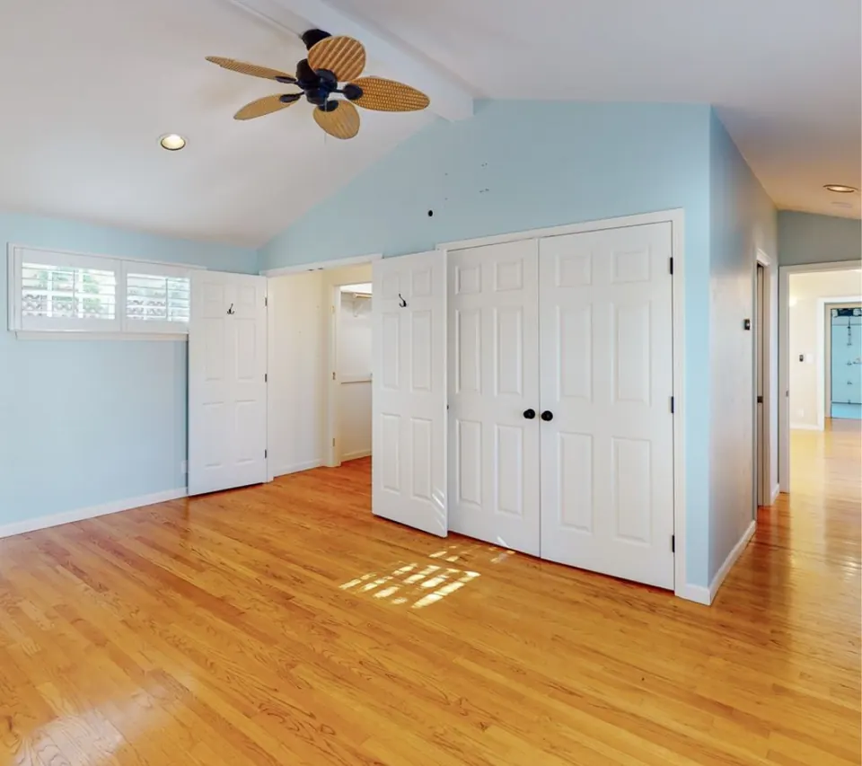 The bedroom before the remodel, with blue walls and standard closet doors