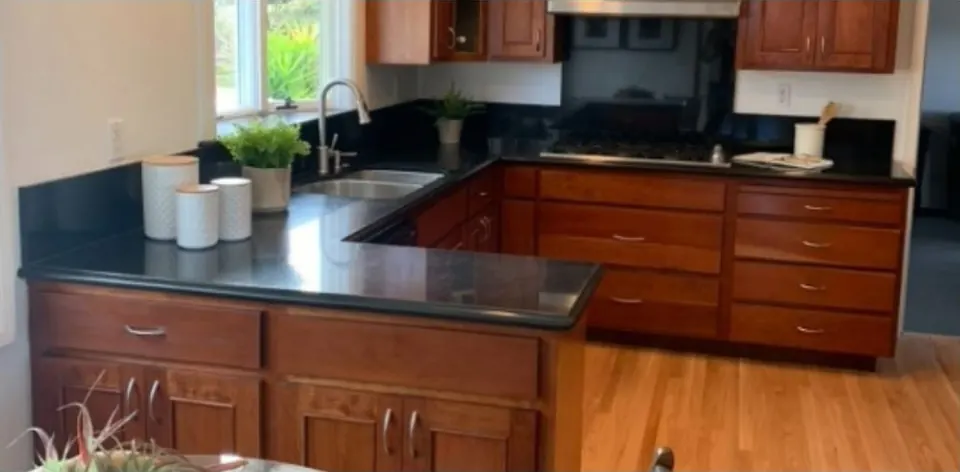 The kitchen before the remodel, with cherry cabinets and black granite counters