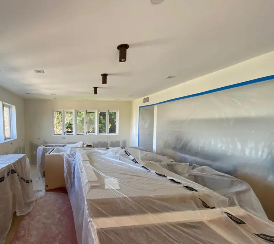 The same kitchen taken down to the studs and protected for construction