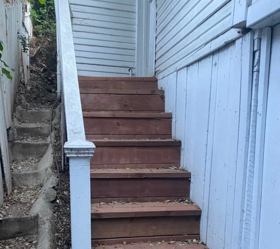 The exterior stairs before the rebuild, with weathered red-stained treads