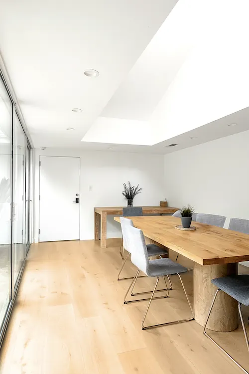 Dining room with a skylight and a full-height glass wall